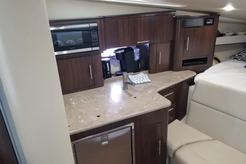 Ships N Giggles Yacht Photos Pics Luxurious interior of 2018 Regal 35 Sport Coupe with modern kitchenette and seating area.