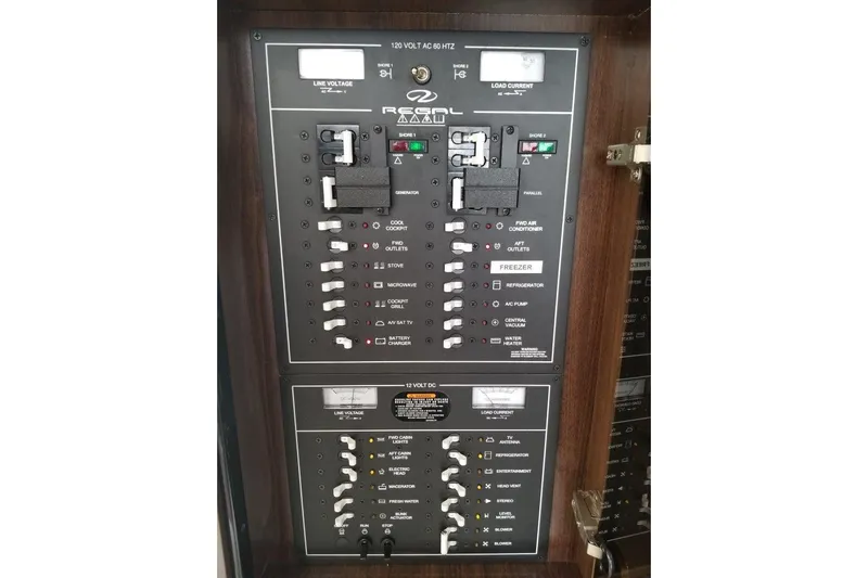 Ships N Giggles Yacht Photos Pics Electrical control panel of a 2018 Regal 35 Sport Coupe boat, featuring various switches and indicators.