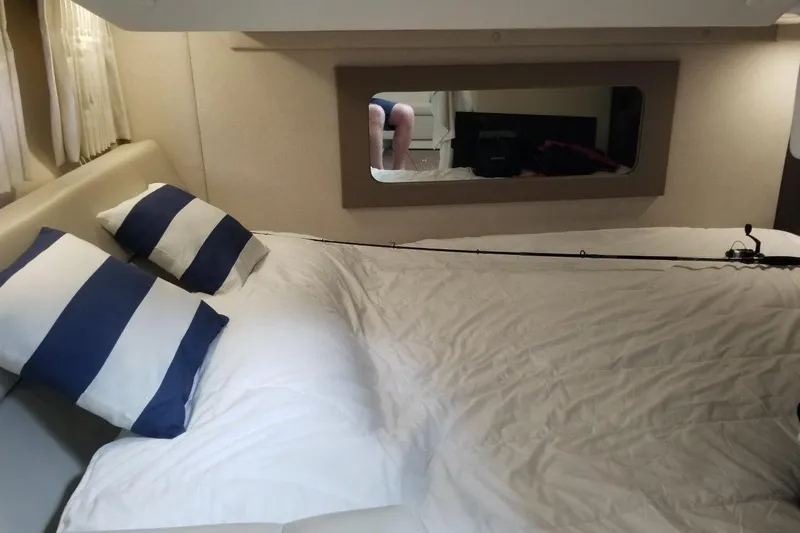 Ships N Giggles Yacht Photos Pics Cozy cabin interior of 2018 Regal 35 Sport Coupe with striped pillows and mirror.