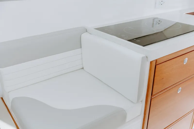  Yacht Photos Pics Modern kitchen area in 2025 ArrowCat 320 boat with sleek cooktop and wooden cabinetry.