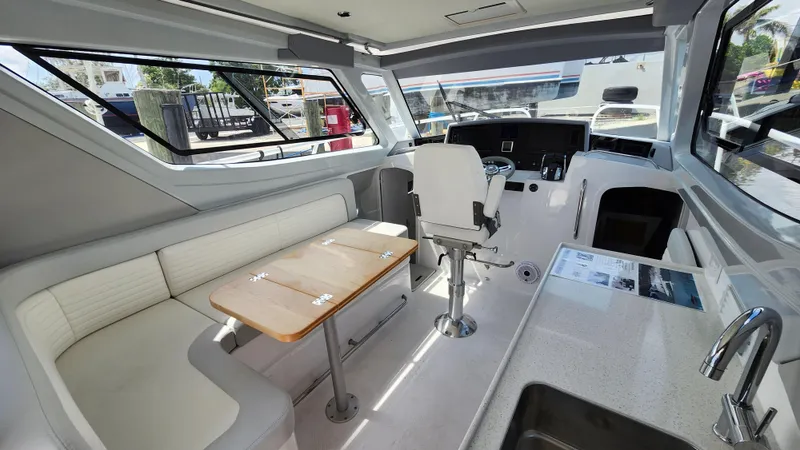  Yacht Photos Pics Interior of 2025 ArrowCat 320 boat with seating, helm, and kitchenette.