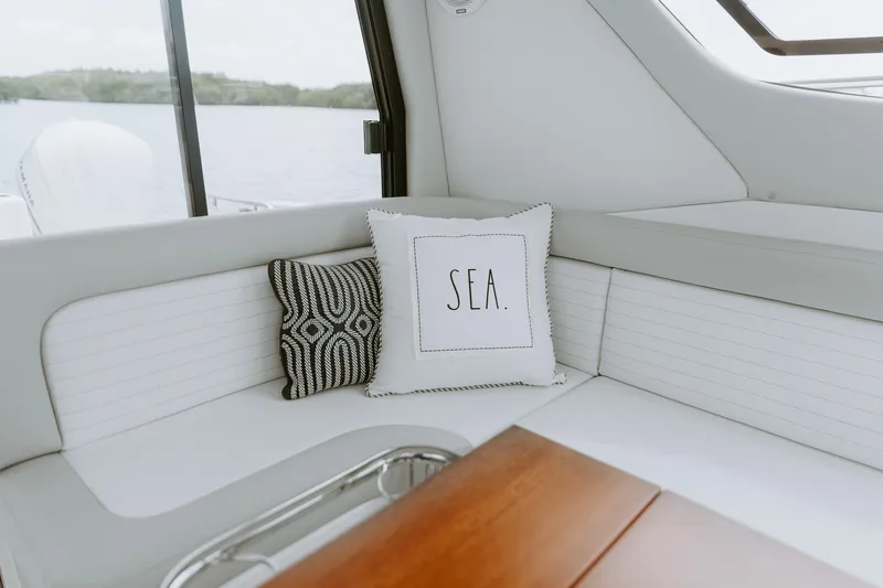  Yacht Photos Pics Luxurious interior of 2025 ArrowCat 320 boat with decorative pillows and wooden table.