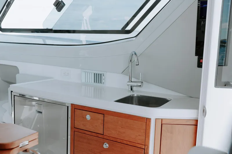  Yacht Photos Pics Modern kitchen area in 2025 ArrowCat 320 boat with sink and wooden cabinets.