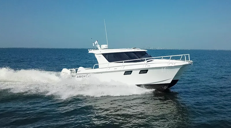  Yacht Photos Pics 2025 ArrowCat 320 cruising on open water under clear blue sky.