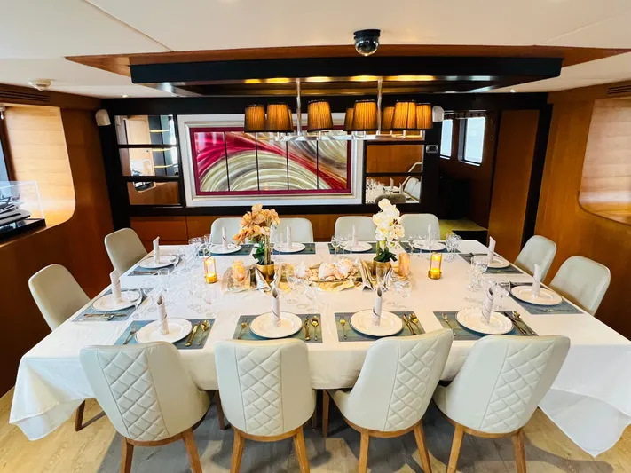  Yacht Photos Pics Luxurious dining area on a 2012 Superyacht 128, featuring elegant table settings and modern decor.