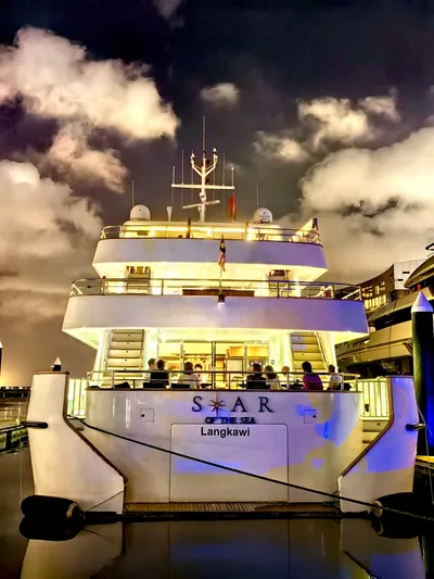  Yacht Photos Pics Luxurious 2012 Superyacht 128 docked at night, Langkawi, illuminated under cloudy sky.