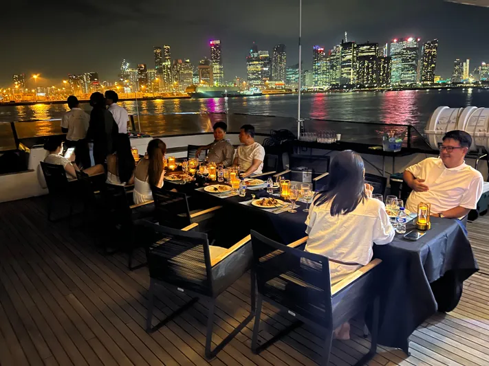  Yacht Photos Pics People dining on a 2012 Superyacht 128, with city skyline view at night.