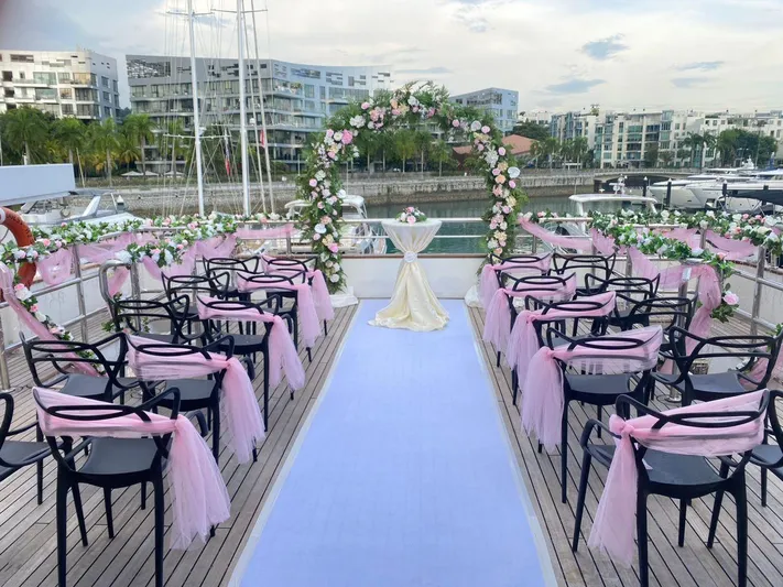  Yacht Photos Pics Wedding setup on a 2012 Superyacht 128, featuring floral arch and pink decorations.