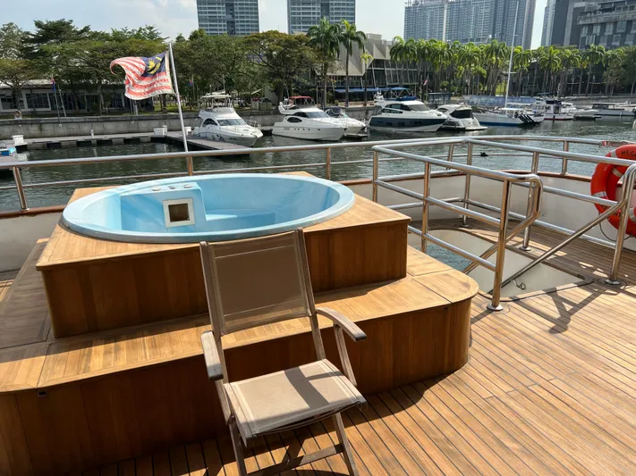  Yacht Photos Pics Deck of 2012 Superyacht 128 with jacuzzi, chair, and marina view.