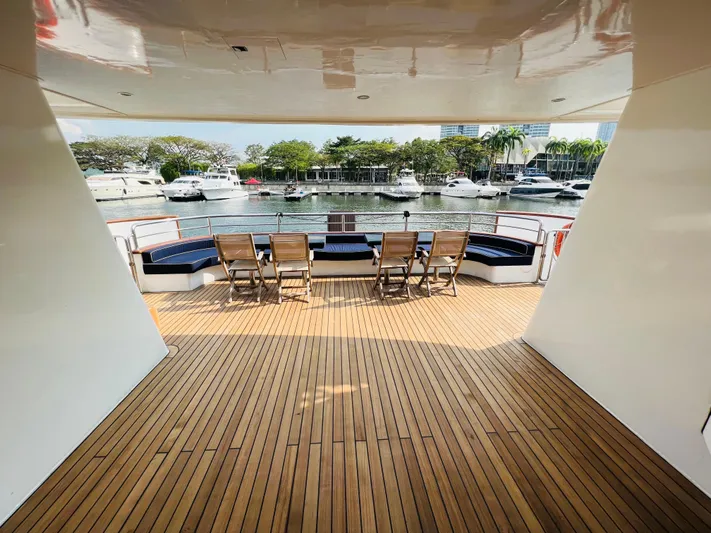  Yacht Photos Pics Spacious deck of 2012 Superyacht 128 with wooden flooring and seating, overlooking marina.