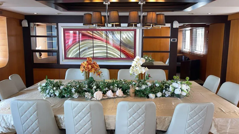  Yacht Photos Pics Luxurious dining area on 2012 Superyacht 128, featuring elegant decor and floral centerpiece.