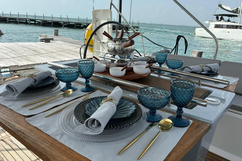 Yacht Photos Pics Elegant dining setup on a 2020 Beneteau Oceanis 41.1 yacht, overlooking serene waters.