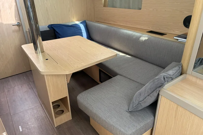  Yacht Photos Pics Modern interior of 2020 Beneteau Oceanis 41.1 yacht with cozy seating and wooden table.