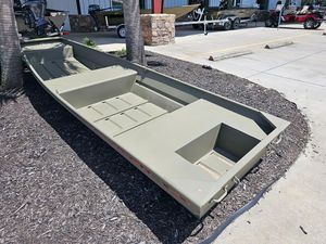 2025 Tracker Grizzly 14 Jon boat displayed outdoors on mulch near a parking lot.