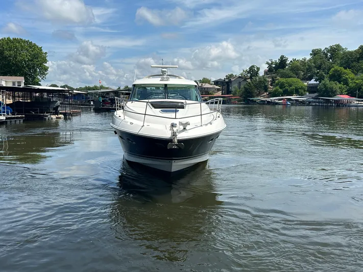  Yacht Photos Pics 2010 Sea Ray 450 Sundancer yacht on a calm lake under a blue sky.