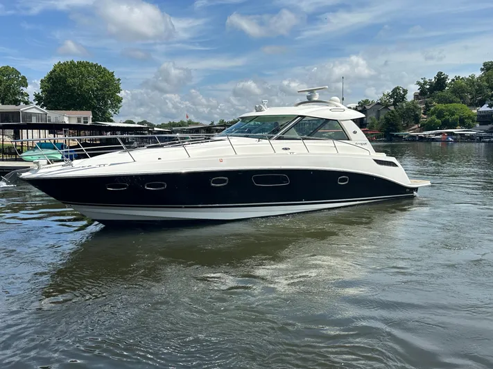  Yacht Photos Pics 2010 Sea Ray 450 Sundancer yacht cruising on a calm lake under a clear sky.
