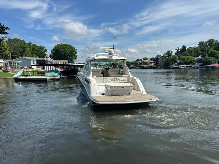  Yacht Photos Pics Sea Ray 450 Sundancer 2010 cruising on a calm lake under a clear blue sky.