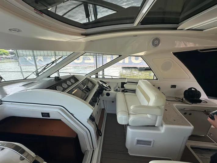  Yacht Photos Pics Interior view of 2010 Sea Ray 450 Sundancer yacht cockpit with white seating and control panel.