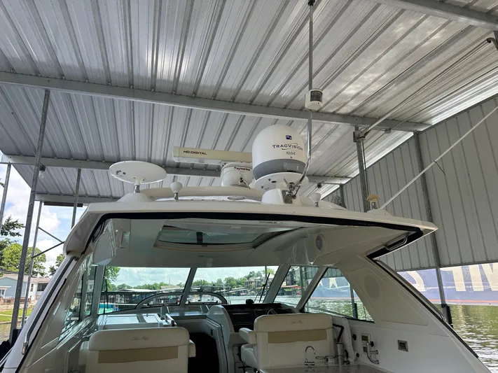  Yacht Photos Pics 2010 Sea Ray 450 Sundancer yacht docked under a metal canopy.