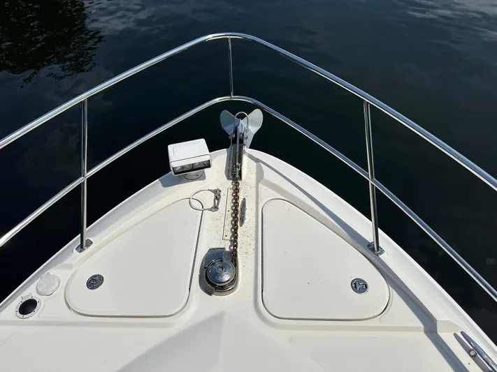  Yacht Photos Pics Bow of 2010 Sea Ray 450 Sundancer with anchor and railing in calm water.