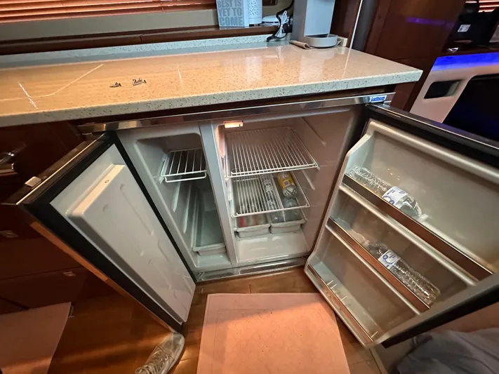  Yacht Photos Pics Open refrigerator inside 2010 Sea Ray 450 Sundancer yacht, showcasing interior shelves and door storage.