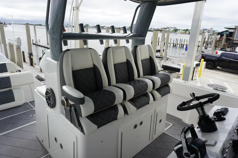 Obsession II Yacht Photos Pics 2023 Insetta 35IFC boat interior with luxury seating and steering console at a marina.