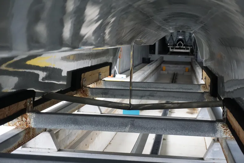 Obsession II Yacht Photos Pics 2023 Insetta 35IFC boat hull on a metal support frame in a workshop.