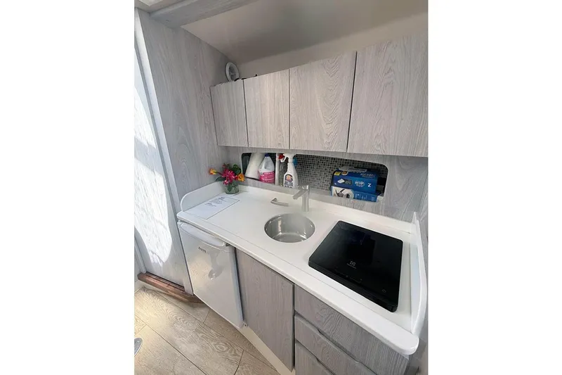  Yacht Photos Pics Compact modern kitchenette in Hanover 375, 2024 model, featuring sleek cabinets and appliances.