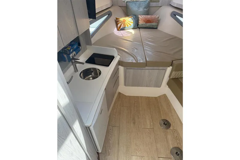  Yacht Photos Pics Compact interior of 2024 Hanover 375 boat with kitchenette and seating area.
