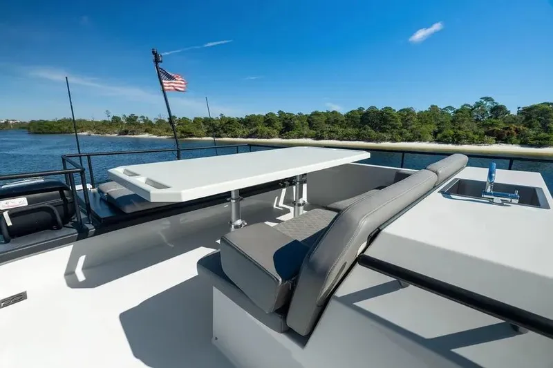  Yacht Photos Pics Luxurious 2019 DutchCraft 56 Open yacht deck with seating and table, overlooking serene waters.