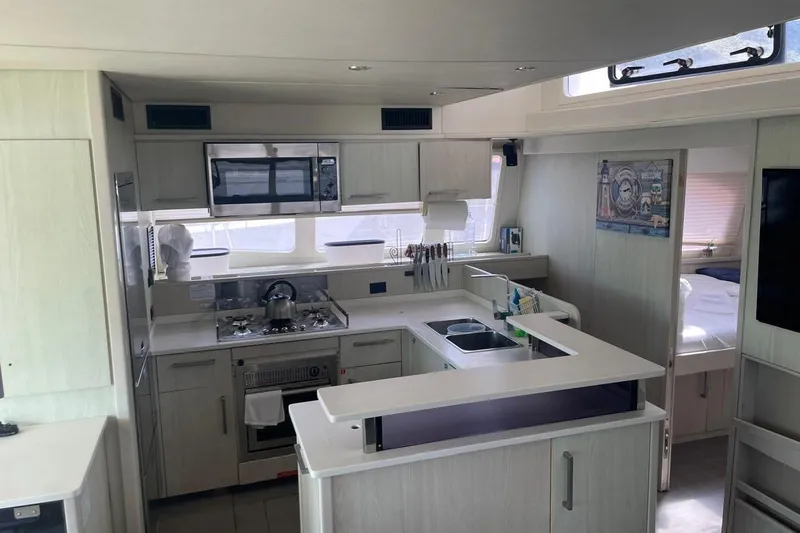  Yacht Photos Pics Modern kitchen interior on a 2015 Leopard 58 yacht, featuring sleek cabinetry and appliances.