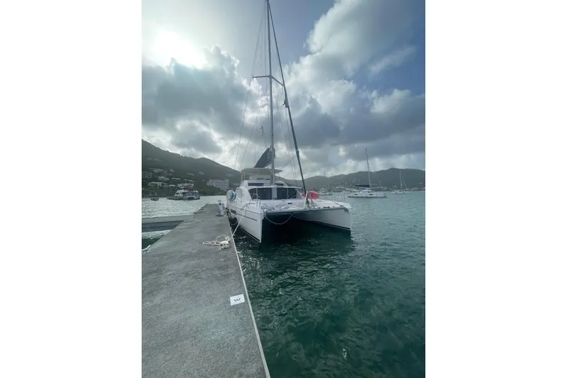  Yacht Photos Pics Sailing catamaran Leopard 58, 2015 model, docked at a marina under cloudy skies.