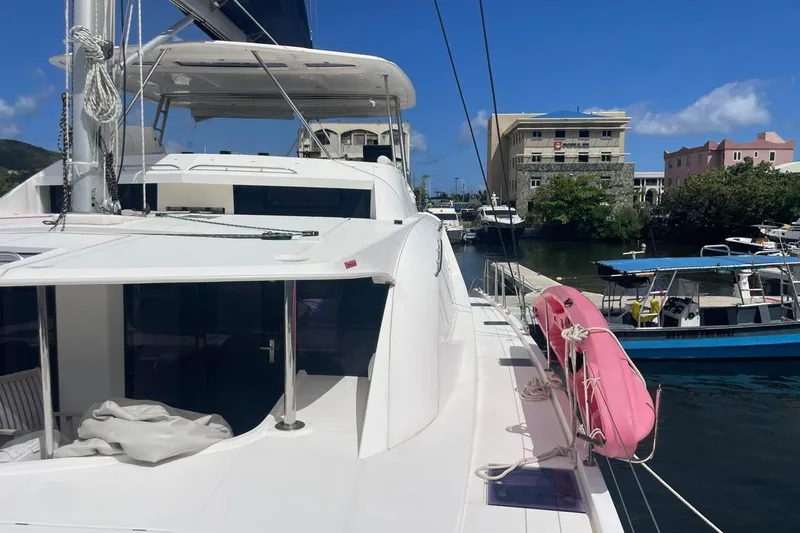  Yacht Photos Pics Leopard 58 yacht docked in marina, featuring a pink lifebuoy and clear blue sky.