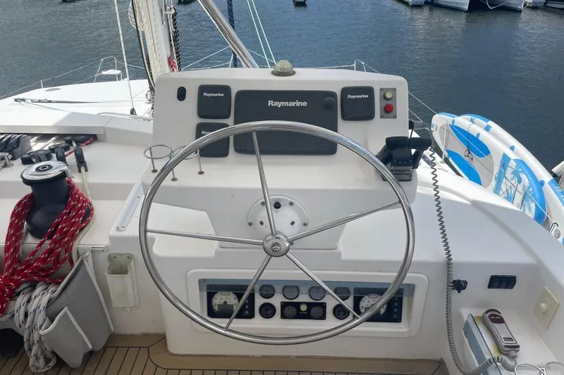  Yacht Photos Pics Steering wheel and controls of a 2015 Leopard 58 yacht, docked at a marina.