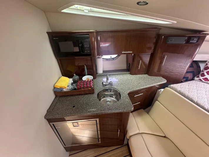 Panacea Yacht Photos Pics Interior of 2015 Regal 35 Sport Coupe with kitchenette and seating area.