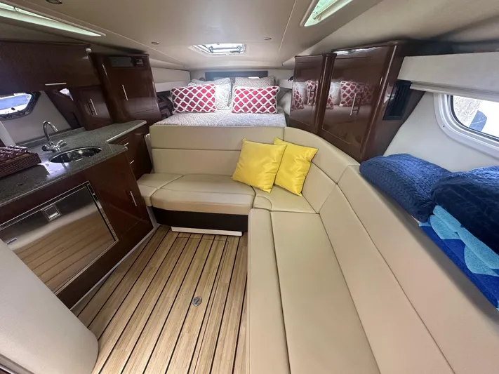 Panacea Yacht Photos Pics Interior of 2015 Regal 35 Sport Coupe with beige seating, kitchenette, and cozy decor.