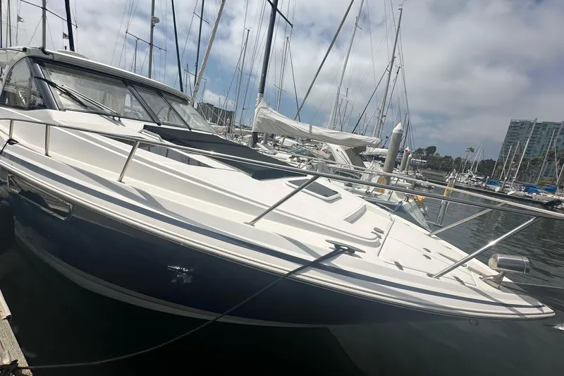 Panacea Yacht Photos Pics 2015 Regal 35 Sport Coupe docked in marina, surrounded by sailboats under cloudy sky.