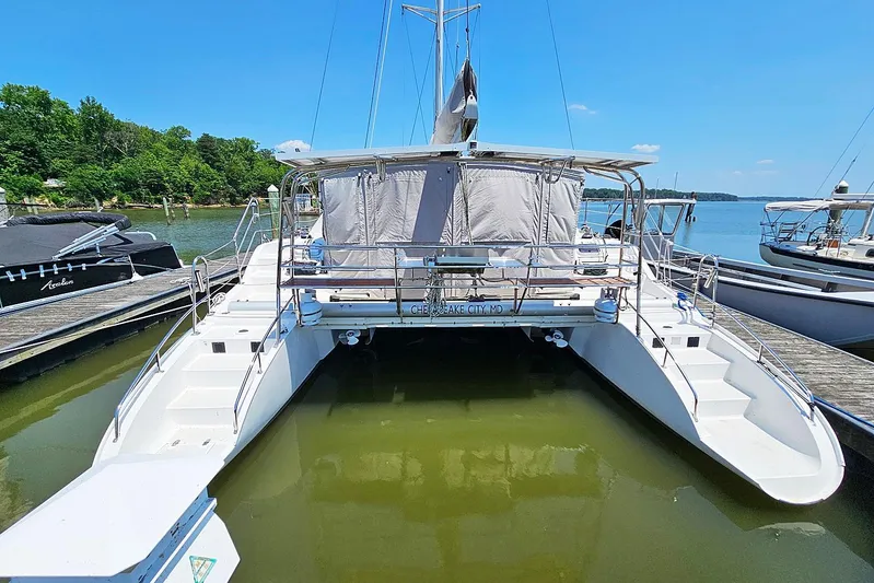 Zephyros Yacht Photos Pics 2009 Seawind 36XL catamaran docked at a marina, surrounded by calm water and trees.