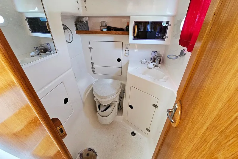Zephyros Yacht Photos Pics 2009 Seawind 36XL yacht bathroom with compact toilet, sink, and storage cabinets.