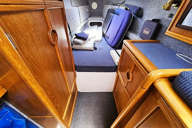 Zephyros Yacht Photos Pics Cozy cabin interior of 2009 Seawind 36XL with wooden cabinetry and blue cushions.