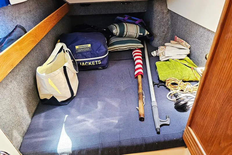 Zephyros Yacht Photos Pics Storage area in a 2009 Seawind 36XL with bags, cushions, and boating gear.