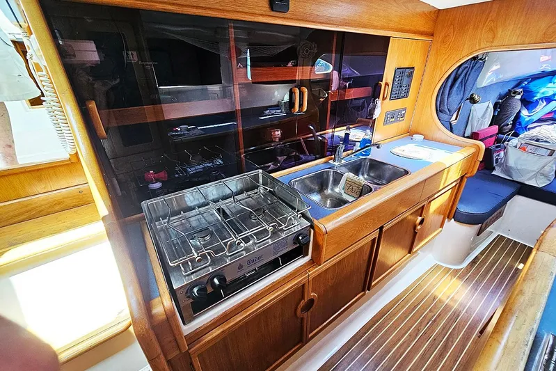 Zephyros Yacht Photos Pics Interior of 2009 Seawind 36XL yacht featuring a compact kitchen with stove and sink.