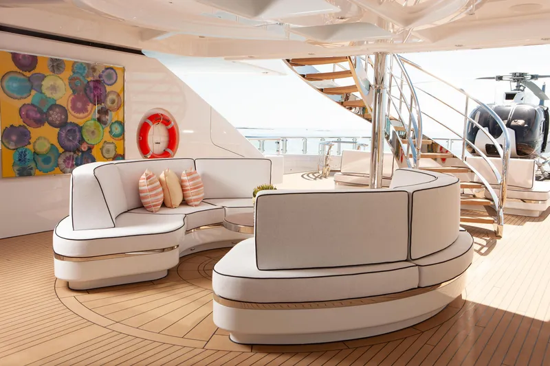 Boardwalk Yacht Photos Pics Luxurious Feadship Costum 2021 yacht deck with modern seating, art, and spiral staircase.