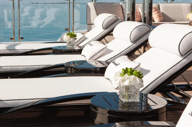 Boardwalk Yacht Photos Pics Luxurious Feadship Costum 2021 yacht deck with elegant sun loungers and floral arrangements.
