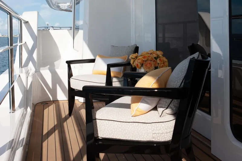 Boardwalk Yacht Photos Pics Luxury yacht deck with elegant seating, yellow cushions, and floral arrangement, Feadship Custom 2021.