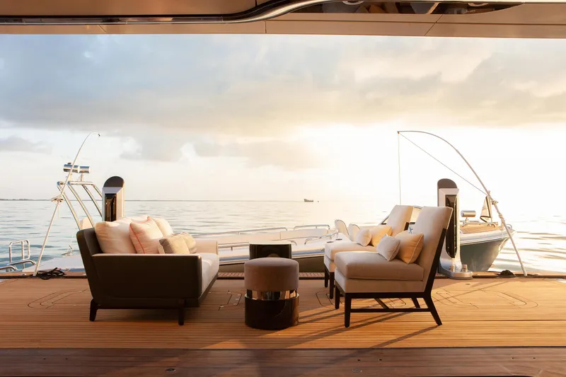 Boardwalk Yacht Photos Pics Luxurious Feadship Custom 2021 yacht deck with elegant seating, overlooking serene ocean at sunset.