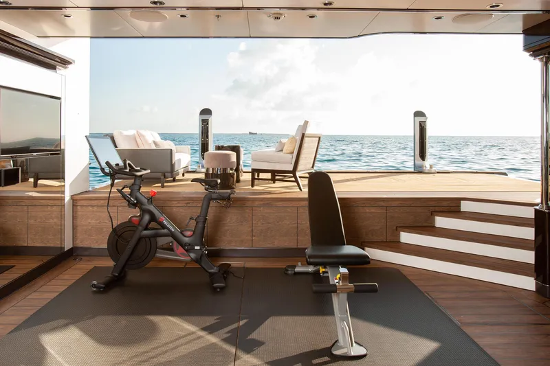 Boardwalk Yacht Photos Pics Luxurious yacht gym with exercise bike and bench, overlooking ocean view. Feadship Custom 2021.