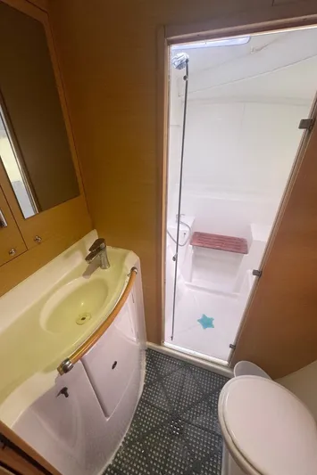 Isaphil Yacht Photos Pics Bathroom interior of a 2013 Lagoon 380 S2 yacht, featuring a sink, toilet, and shower.