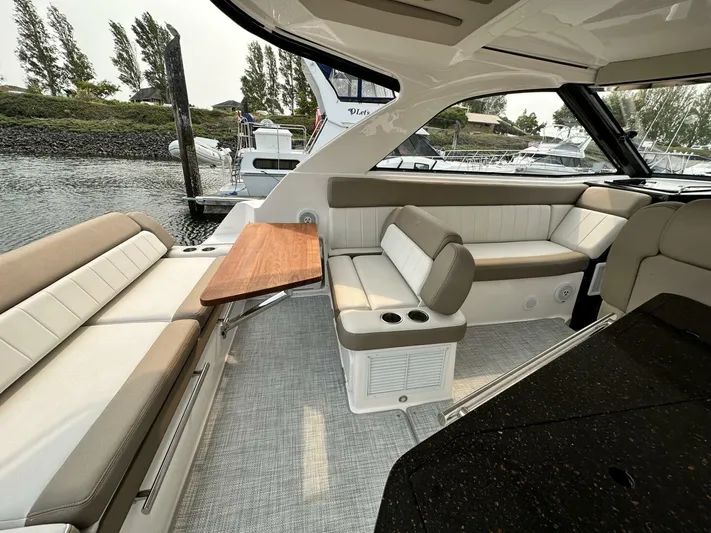  Yacht Photos Pics Luxurious interior of a 2014 Regal Sport Coupe boat with elegant seating and wooden table.