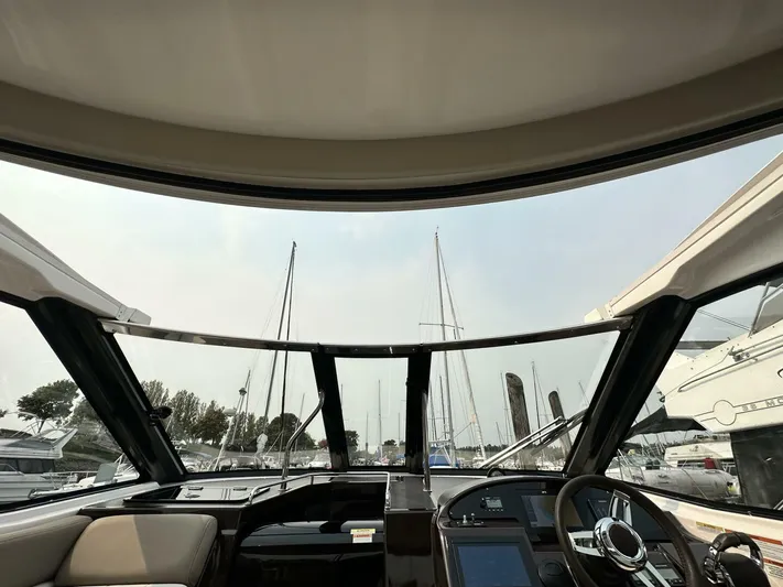 Yacht Photos Pics Interior view of a 2014 Regal Sport Coupe boat, showcasing the helm and marina backdrop.